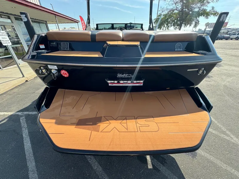 Slide: The Image of 2021 Axis A22 boat rear view with teak swim platform in a parking lot. - 9
