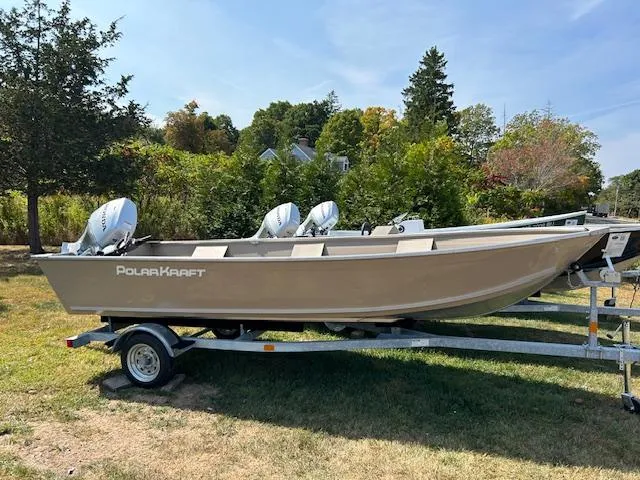Slide: The Image of 2024 Polar Kraft Dakota 1670T boat on trailer, parked on grass with trees in background. - 2
