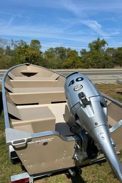 Slide: The Image of 2024 Polar Kraft Dakota 1670T boat with 40 HP motor, parked outdoors. - 6