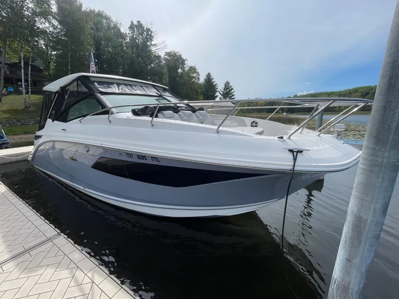 Slide: The Image of 2020 Sea Ray Sundancer 320 docked on a calm lake with trees in the background. - 0