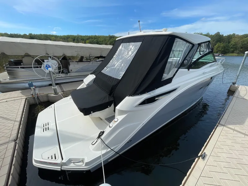 Slide: The Image of 2020 Sea Ray Sundancer 320 docked, featuring sleek design and black canopy. - 1