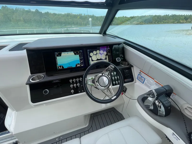 Slide: The Image of 2020 Sea Ray Sundancer 320 helm with modern controls and navigation screens. - 19