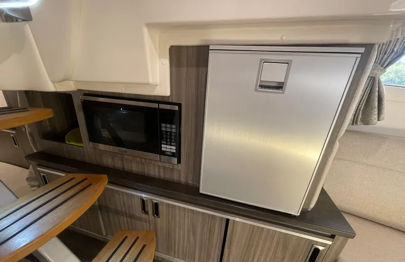 Slide: The Image of 2020 Sea Ray Sundancer 320 interior with microwave and fridge. - 23