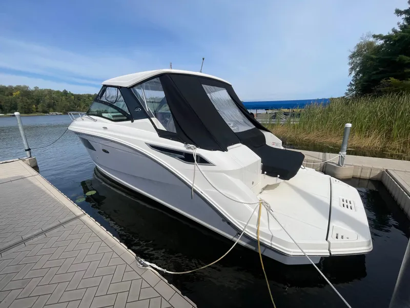 Slide: The Image of 2020 Sea Ray Sundancer 320 docked at a marina, featuring sleek design and black canopy. - 3