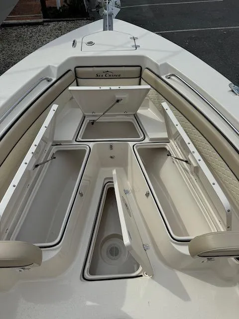 Slide: The Image of 2022 Sea Chaser 22 HFC boat with open storage compartments and seating. - 13