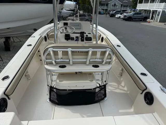 Slide: The Image of 2022 Sea Chaser 22 HFC boat interior with console and seating, parked in a marina. - 17