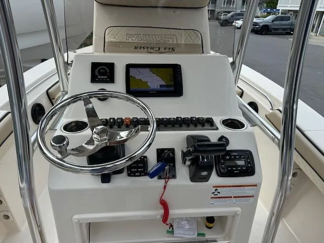 Slide: The Image of 2022 Sea Chaser 22 HFC boat console with steering wheel and navigation system. - 2