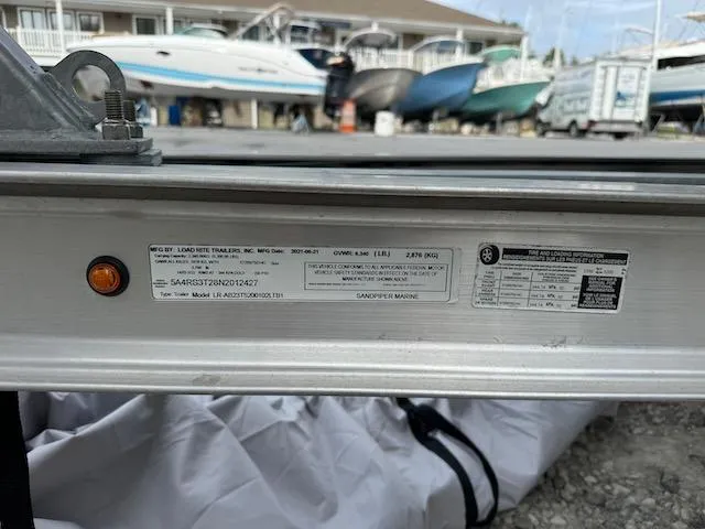 Slide: The Image of Trailer label close-up with boats in the background at a marina. Sea Chaser 22 HFC, 2022. - 20