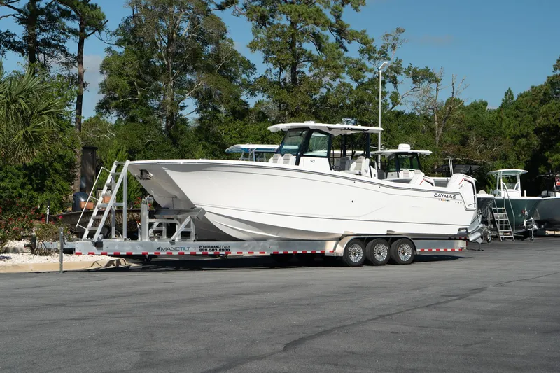 The Image of 2025 Caymas 34 CT boat on a trailer, parked outdoors with trees in the background. - 0