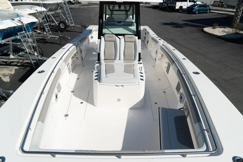 Slide: The Image of 2025 Caymas 34 CT boat with spacious deck and modern seating, docked outdoors. - 10