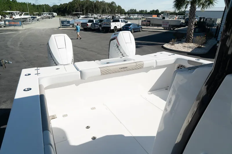 Slide: The Image of 2025 Caymas 34 CT boat with dual engines, displayed in a sunny outdoor showroom. - 11