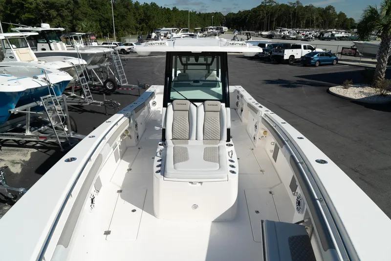 Slide: The Image of 2025 Caymas 34 CT boat with spacious deck and seating, displayed in a marina. - 12
