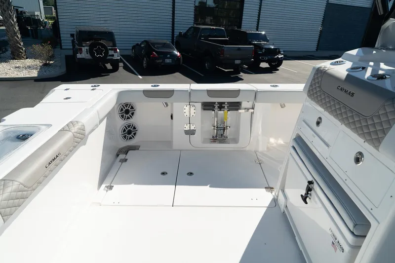 Slide: The Image of 2025 Caymas 34 CT boat interior with seating, storage, and speakers in a parking lot. - 14