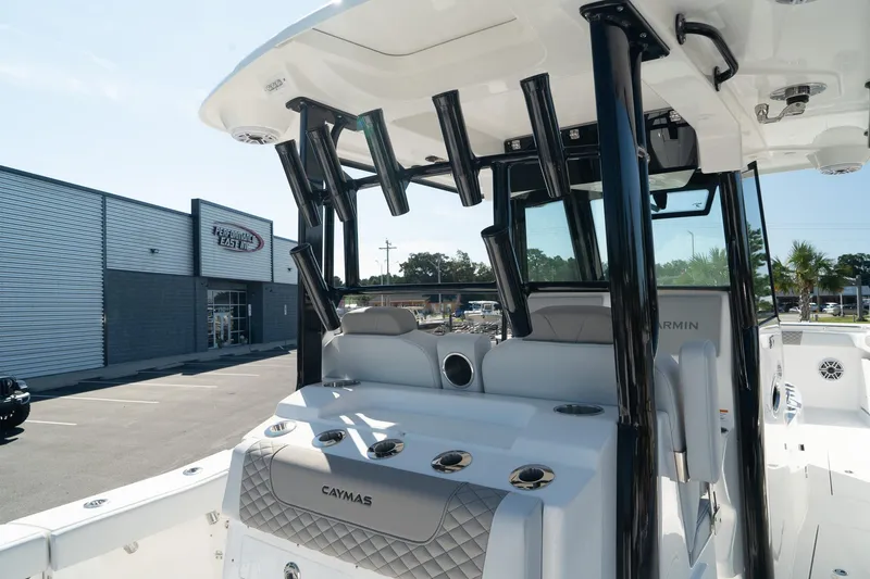 Slide: The Image of 2025 Caymas 34 CT boat with sleek design and modern features, docked near a dealership. - 17