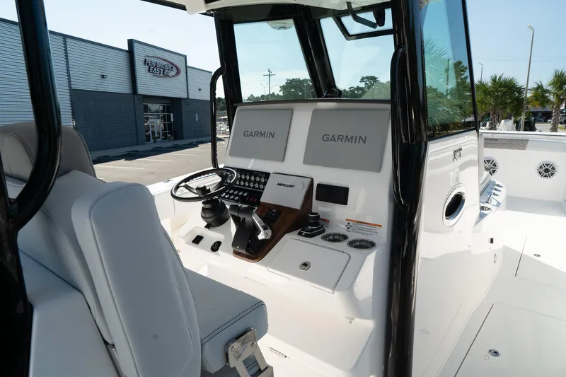 Slide: The Image of 2025 Caymas 34 CT boat cockpit with Garmin navigation displays and modern controls. - 18
