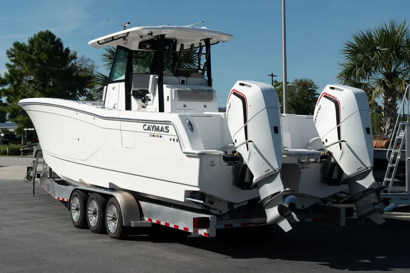 Slide: The Image of 2025 Caymas 34 CT boat on trailer, featuring dual outboard engines. - 2