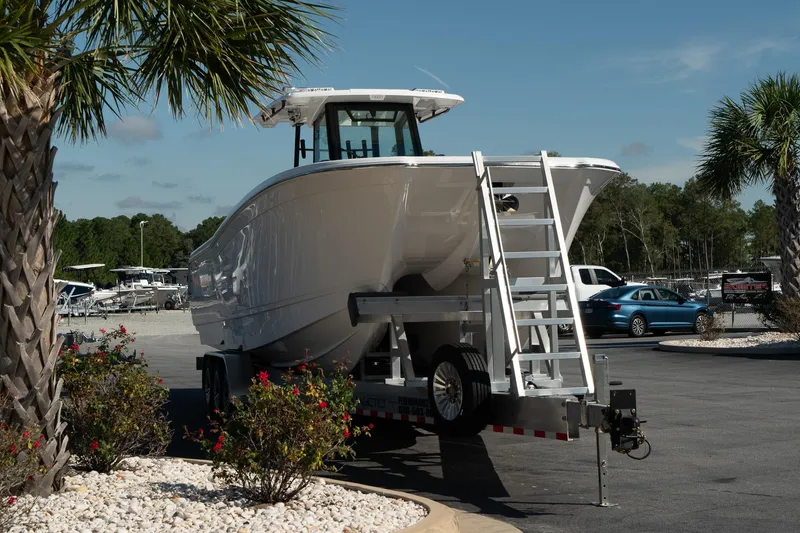 Slide: The Image of 2025 Caymas 34 CT boat on trailer, parked outdoors under clear sky. - 3