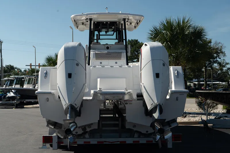 Slide: The Image of 2025 Caymas 34 CT boat with dual outboard engines, parked outdoors. - 4