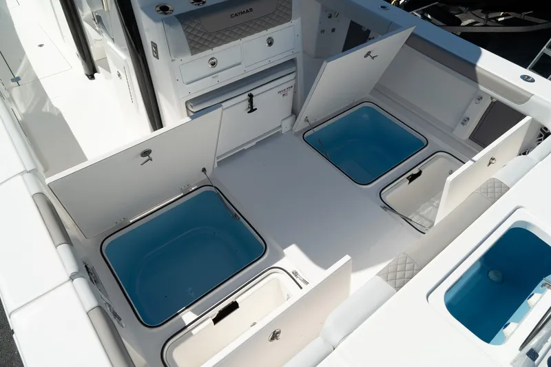 Slide: The Image of 2025 Caymas 34 CT boat interior with open storage compartments and blue-lined wells. - 7