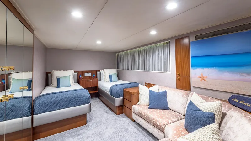Slide: The Image of Luxurious yacht cabin with twin beds, sofa, and beach-themed decor, Feadship Custom 1985. - 13