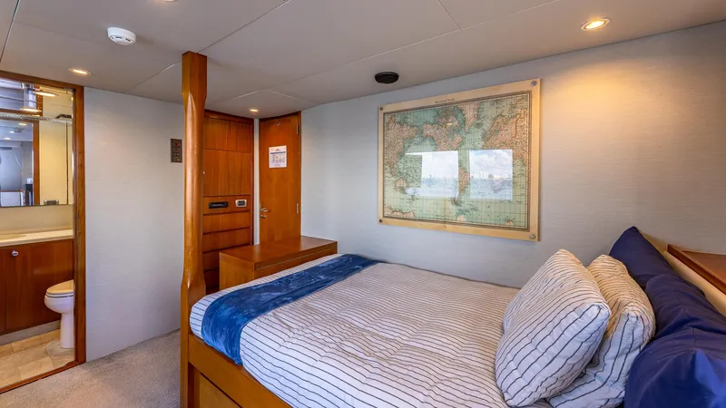 Slide: The Image of Cozy yacht bedroom with map decor, striped bedding, and ensuite bathroom. Feadship Custom 1985. - 18