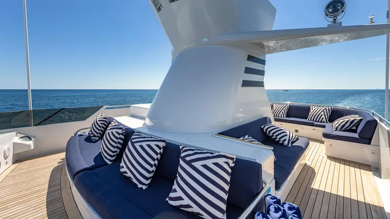 Slide: The Image of Luxurious 1985 Feadship Custom yacht deck with striped cushions, ocean view. - 23