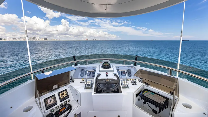 Slide: The Image of Helm of 1985 Feadship Custom yacht overlooking ocean and distant city skyline. - 25