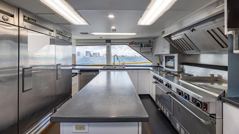 Slide: The Image of Luxurious yacht kitchen with modern appliances, featuring a spacious countertop and ocean view. Feadship Custom 1985. - 28