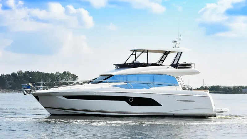 The Image of 2019 Prestige 520 Flybridge yacht cruising on calm waters under a blue sky. - 0