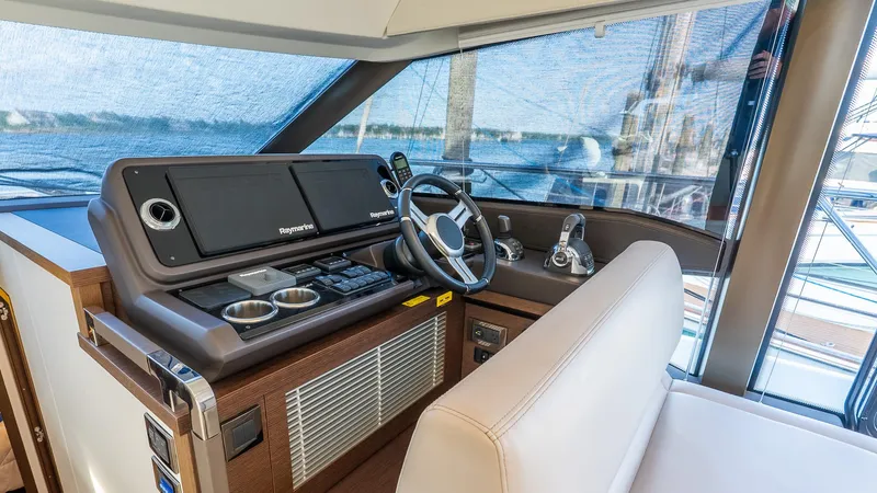 Slide: The Image of 2019 Prestige 520 Flybridge helm with Raymarine navigation system and luxurious seating. - 14