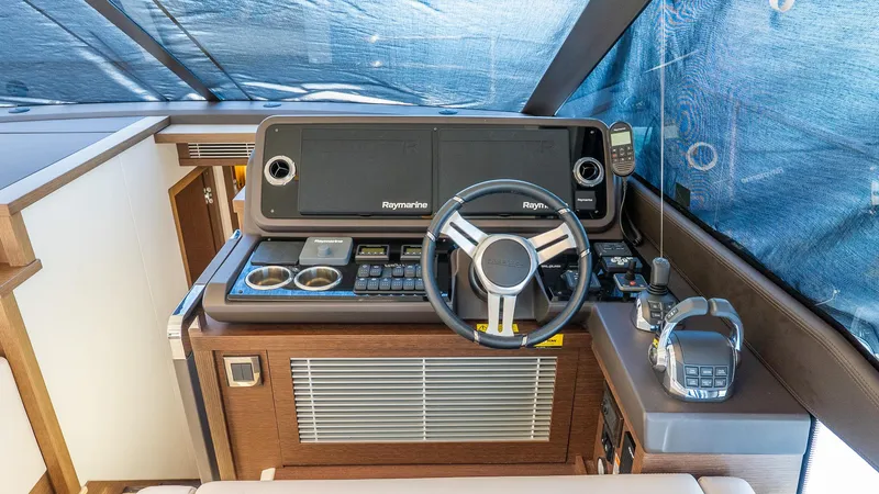 Slide: The Image of 2019 Prestige 520 Flybridge helm with Raymarine electronics and modern controls. - 15