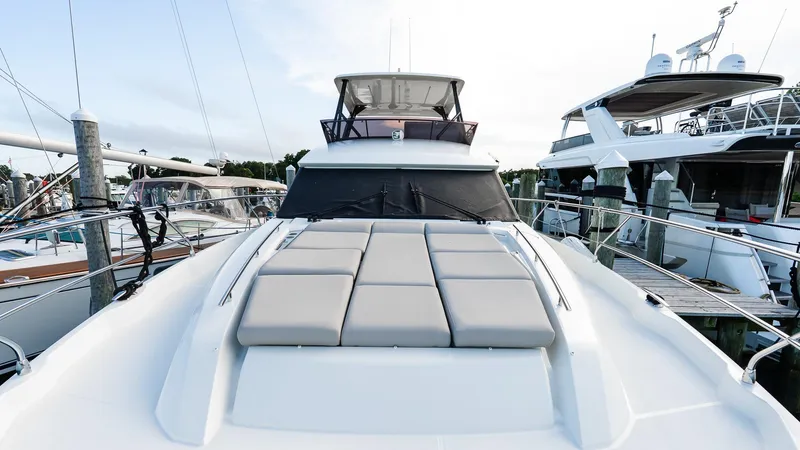 Slide: The Image of 2019 Prestige 520 Flybridge yacht docked, featuring spacious sunbathing area and sleek design. - 27