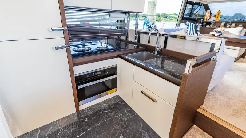 Slide: The Image of Modern kitchen in a 2019 Prestige 520 Flybridge yacht with sleek appliances and marble countertops. - 7