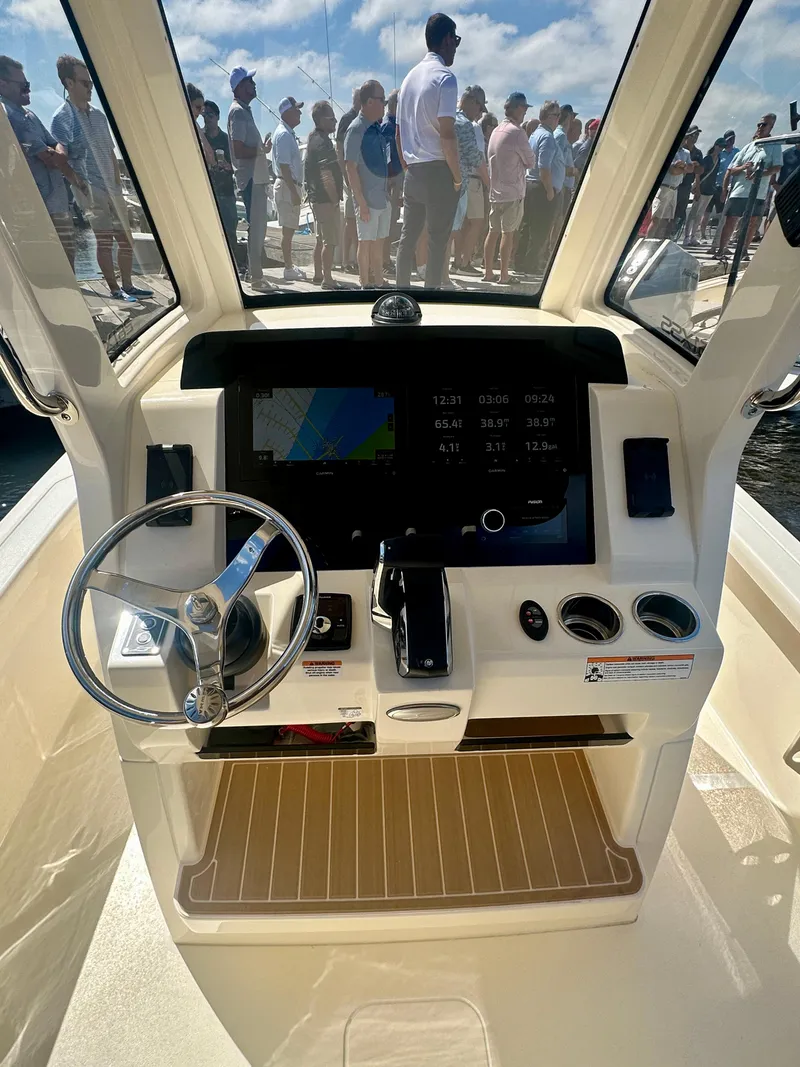 Slide: The Image of 2026 Scout 261 XSS boat dashboard with steering wheel and navigation display. - 2