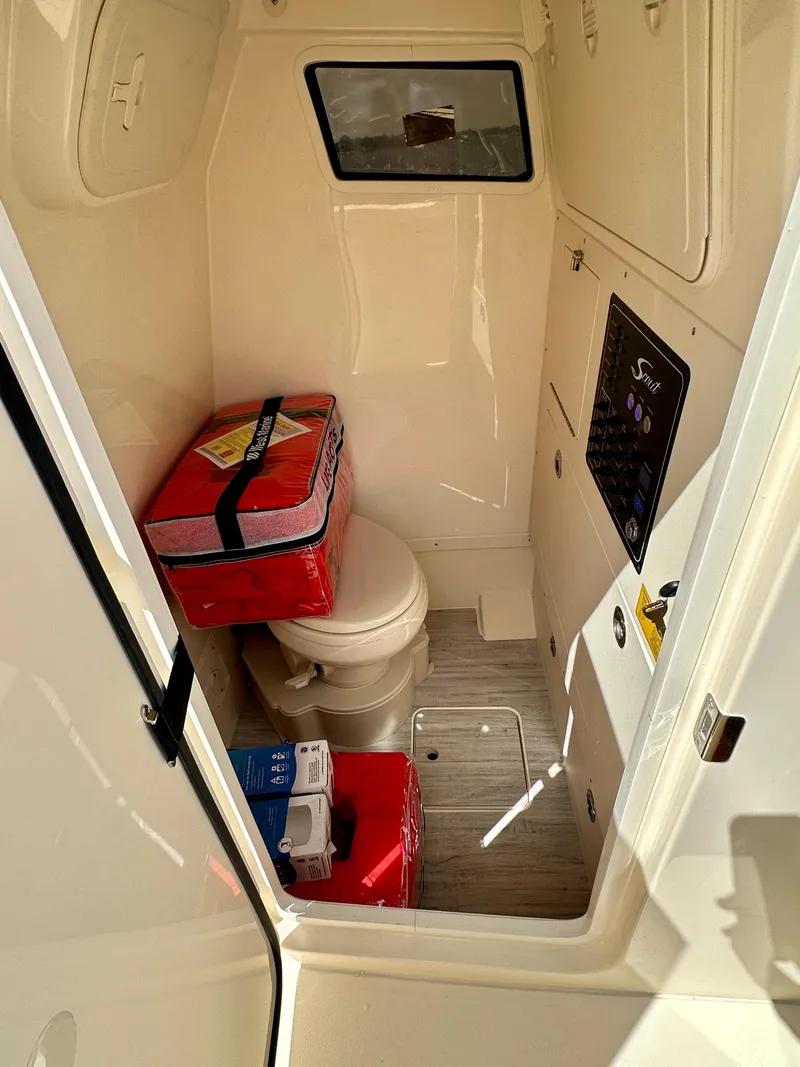 Slide: The Image of 2026 Scout 261 XSS boat interior with compact restroom and storage. - 8