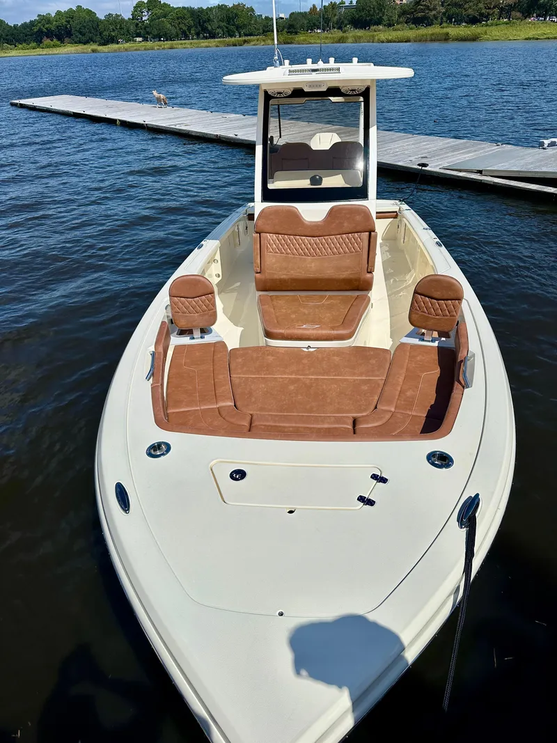 Slide: The Image of 2026 Scout 261 XSS boat docked on calm water, featuring sleek design and brown seating. - 9