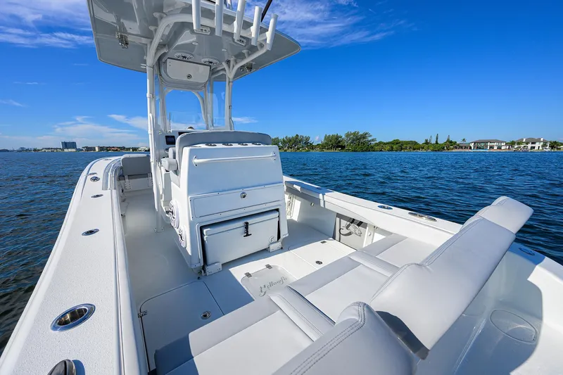 Slide: The Image of 2021 Yellowfin 26 Hybrid boat on calm water under clear blue sky. - 11