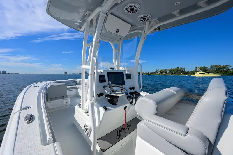 Slide: The Image of 2021 Yellowfin 26 Hybrid boat interior with steering console on a sunny day. - 13