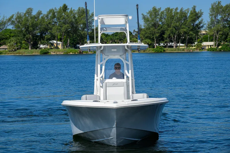 Slide: The Image of 2021 Yellowfin 26 Hybrid boat on calm water, front view. - 2