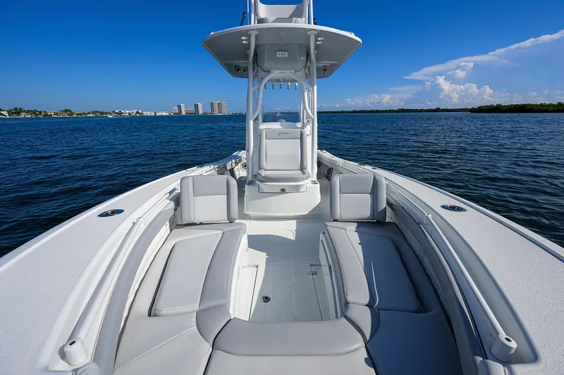 Slide: The Image of 2021 Yellowfin 26 Hybrid boat on calm water, showcasing spacious deck and seating. - 7