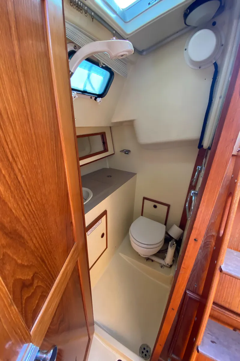 Slide: The Image of 1988 Pearson 28 sailboat bathroom with wooden accents and compact design. - 18