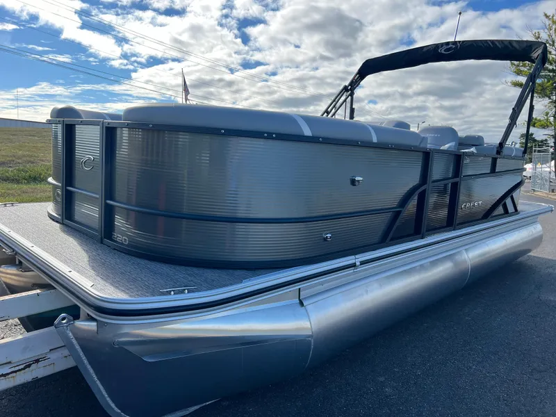 Slide: The Image of 2025 Crest CLASSIC 220 SLC pontoon boat on trailer under cloudy sky. - 10