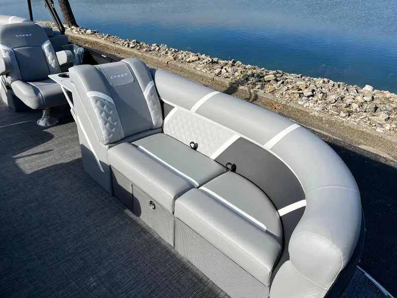 Slide: The Image of Luxury seating on 2025 Crest CLASSIC 220 SLC pontoon boat by the water. - 13