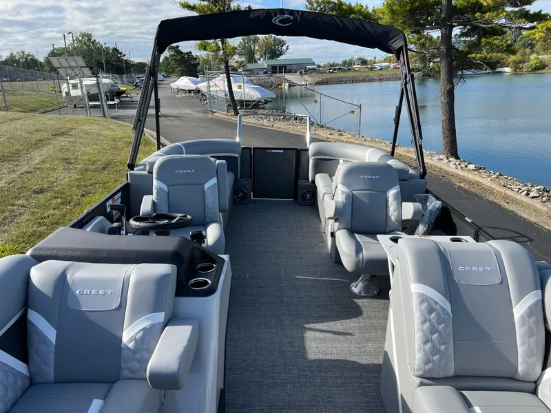Slide: The Image of 2025 Crest CLASSIC 220 SLC pontoon boat with luxurious seating by a serene lake. - 15
