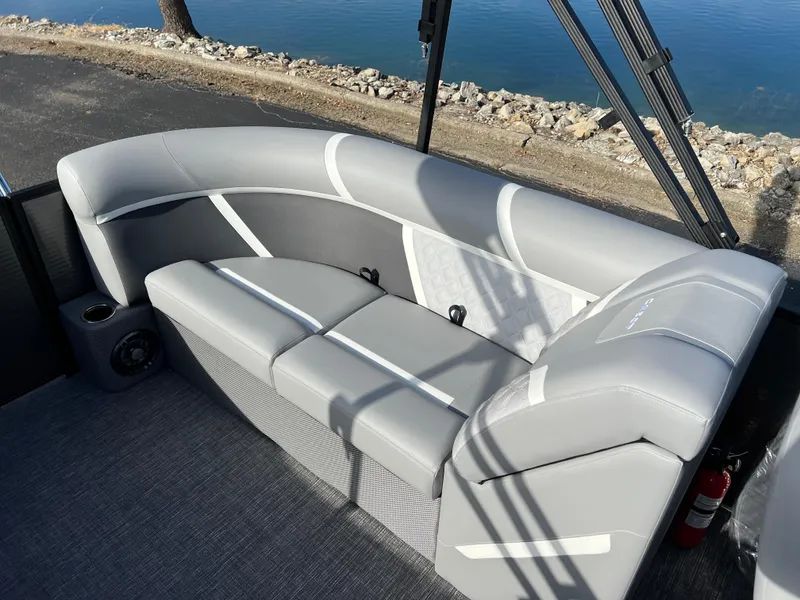 Slide: The Image of 2025 Crest CLASSIC 220 SLC boat with gray seating, near a waterfront. - 19