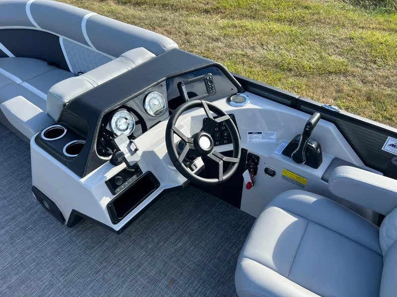 Slide: The Image of 2025 Crest CLASSIC 220 SLC boat interior with modern steering console and comfortable seating. - 23