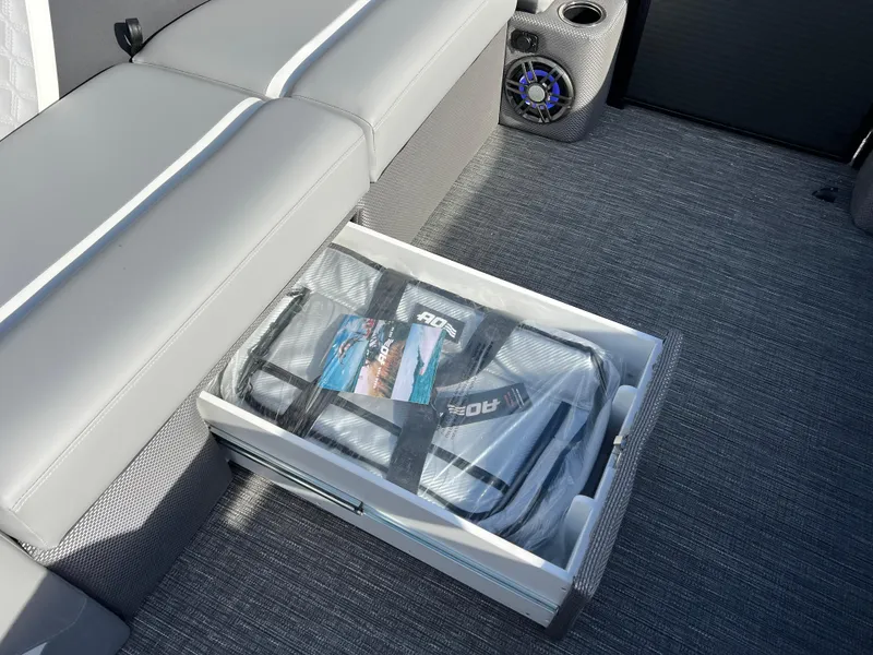 Slide: The Image of Storage compartment in 2025 Crest CLASSIC 220 SLC boat with gray seating and speaker. - 30
