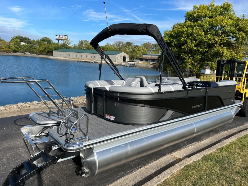 Slide: The Image of 2025 Crest CLASSIC 220 SLC pontoon boat docked by a serene lake. - 4