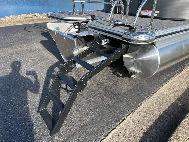 Slide: The Image of 2025 Crest CLASSIC 220 SLC pontoon boat with foldable ladder on a sunny day. - 5