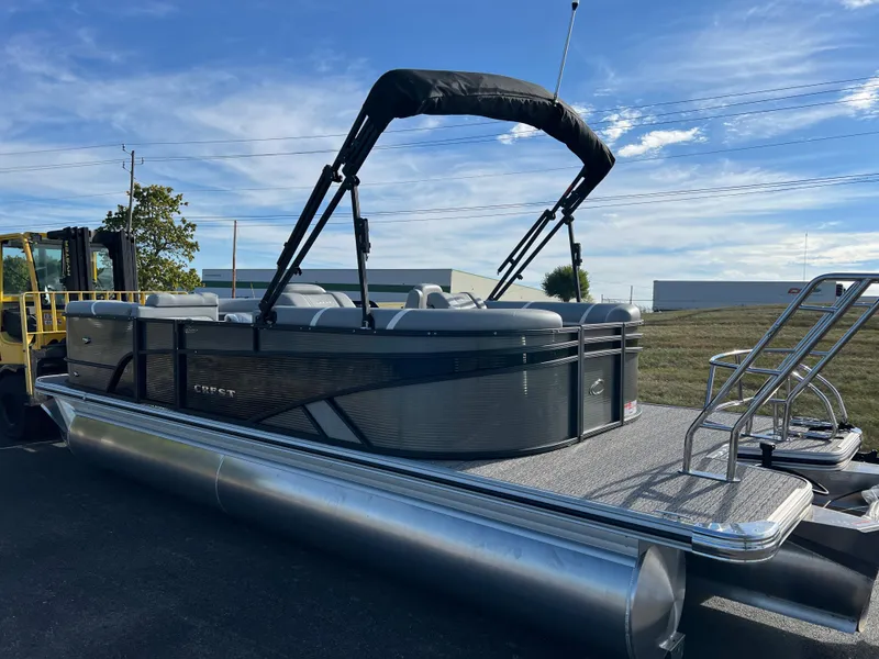 Slide: The Image of 2025 Crest CLASSIC 220 SLC pontoon boat with canopy, parked outdoors. - 9